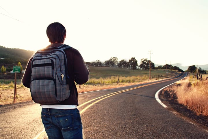 Man with a backpack on a journey on a road.