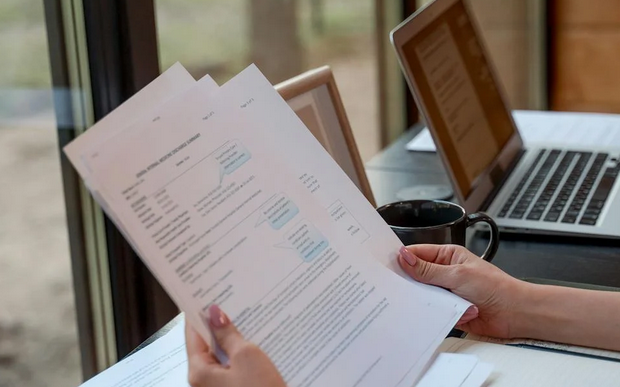 Person reviewing resumes.